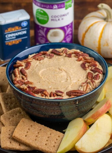 Pumpkin cheesecake dip in a bowl served with homemade graham crackers and apple slices