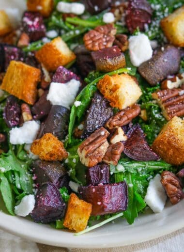 closeup image of roasted beet and feta salad with arugula, croutons, and vegan feta