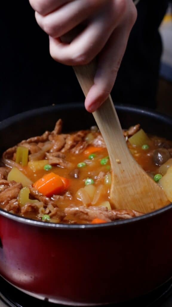mixing the pot of vegan beef stew