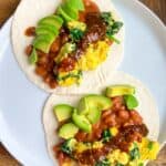 two high-protein vegan breakfast tacos on a plate with salsa